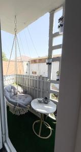 een veranda met een hangmat en een tafel op een balkon bij Восточный уют 2 in Samarkand