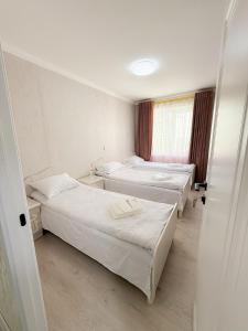 een kamer met drie bedden en een raam bij Восточный уют 2 in Samarkand +6 foto's