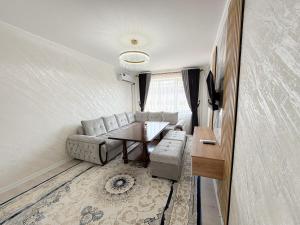 een woonkamer met een bank en een tafel bij Восточный уют 2 in Samarkand
