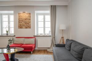 - un salon avec un canapé et un fauteuil rouge dans l'établissement Twin apartments 3 Bedr by Reside Baltic, à Vilnius