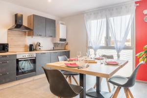 a kitchen with a wooden table and chairs in a kitchen at La route verte in Docelles +2 photos