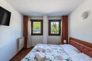 a bedroom with a bed and two windows at Sogno di Montagna sulle piste da Sci in Bardonecchia
