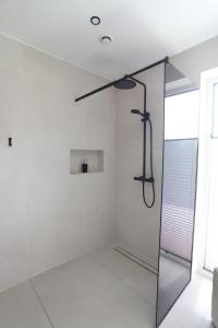 a shower in a white bathroom with a glass door at Kvissentali House in Tartu +15 photos