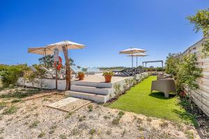 a backyard with a table and chairs and umbrellas at Craveira Country House - Monte da Craveira in Sonega