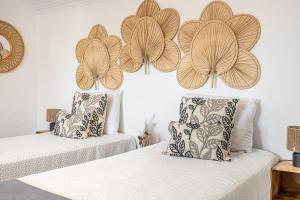 two beds in a room with flowers on the wall at Craveira Country House - Monte da Craveira in Sonega