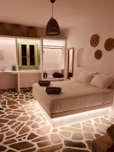 a bedroom with two beds in a room with a rug at ZIMARAKI Houses in Chora Folegandros