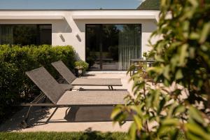 two chairs and a table in front of a house at Agriturismo Insolito in Terlano