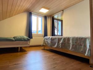 布格多夫Schlafen unterm Dach in Burgdorf CH的有一张床和两扇窗户的房间