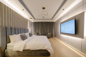 een slaapkamer met een bed en een flatscreen-tv bij Luxuries Apt,Self-Entry,65 4K TV Smart A4 in Riyad