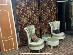 three chairs in front of a wall with flowers at 1 Bedroom Studio innara Rooms Bhurban K3 in Bhurban