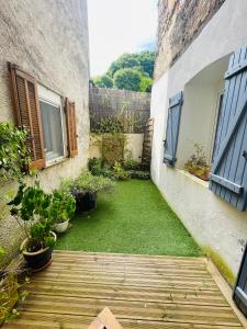 a small courtyard with a yard of grass next to a building at La Conque Provençale in Flayosc
