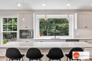 ソーガタックにあるDestined for Relaxationの白い大きな島(黒い椅子付)のあるキッチン