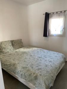 ein Bett in einem weißen Schlafzimmer mit Fenster in der Unterkunft Un jour en Provence in Cabannes