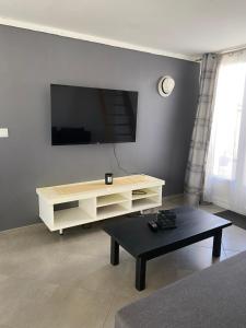 ein Wohnzimmer mit Fernseher und Couchtisch in der Unterkunft Un jour en Provence in Cabannes
