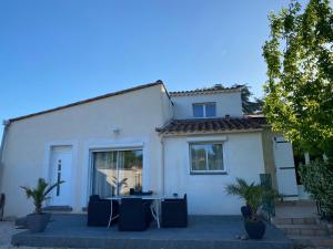 ein weißes Haus mit einem Tisch davor in der Unterkunft Un jour en Provence in Cabannes