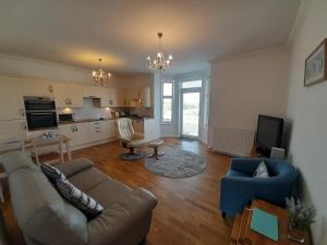 a living room with a couch and chairs and a kitchen at Seabreeze in Whitehills