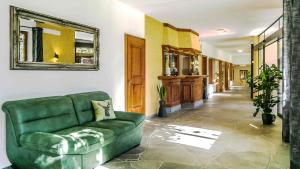 a living room with a green couch in a hallway at Ferienwohnung Allgäu Natur & Spa in Wiggensbach