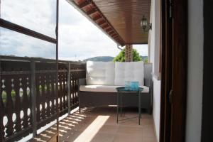 a balcony with a white couch and a table at Ferienwohnungen Natürliches Wohnen in Beckingen