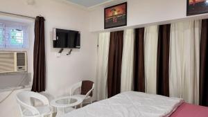 a hospital room with a bed and a table and chairs at Peaceful Studio With Kitchen & Terrace 301 in Patna