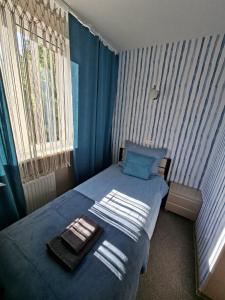 a bedroom with a blue bed with towels on it at Marynarski z kuchnią i łazienką in Koszalin