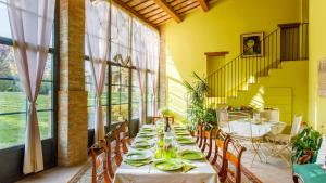 a dining room with a long table with plates on it at La Tana del Ghiro 18, Emma Villas in Ravenna