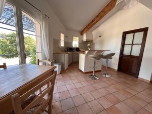 a kitchen with a table and a counter top at Clos des Cassis - Maison d'Hôtes in Villeneuve
