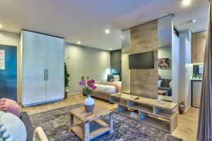 a living room with a bed and a television at St Martini Gardens Studio in Cape Town