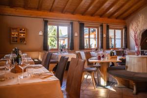 una sala da pranzo con tavoli, sedie e finestre di Chalet Cima Uomo a Passo San Pellegrino