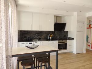 a kitchen with white cabinets and a table with stools at Cala Gonzalez Superior Orange Costa in Alcossebre