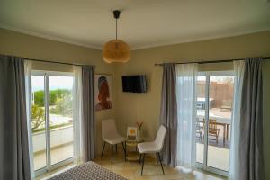 a room with sliding glass doors and a table and chairs at Arrifana Destination Suites in Aljezur