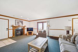 un soggiorno con divano e camino di Spacious 4BR Lakefront Cottage - Perfect for Groups a Lincoln Junction
