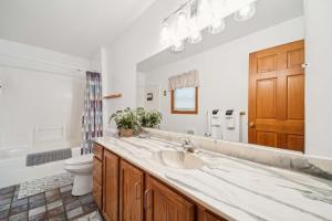 un bagno con lavandino, WC e specchio di Spacious 4BR Lakefront Cottage - Perfect for Groups a Lincoln Junction