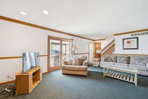 un soggiorno con un divano e una televisione di Spacious 4BR Lakefront Cottage - Perfect for Groups a Lincoln Junction