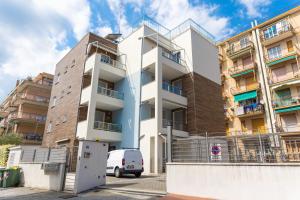 Una camioneta blanca estacionada frente a un edificio en Sirio - bilocale comodo a 200 m dal mare e con piscina sul tetto, en Borghetto Santo Spirito