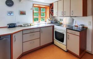 a kitchen with white cabinets and a stove top oven at 2 Bedroom Amazing Home In Samsø in Toftebjerg