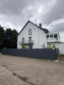 ein weißes Haus mit einem Zaun davor in der Unterkunft kleine und charmante Monteurs Unterkunft C in Karlsruhe