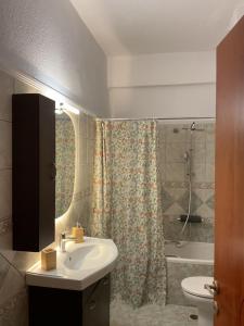 a bathroom with a sink and a toilet and a shower at Villa Vasiliki in Metamorfosi +137 photos