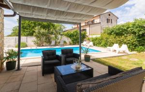 a patio with chairs and a table and a pool at Beautiful Home In Prhati in Prhati
