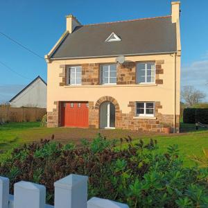 プルガヌーにあるMaison de vacances vue mer et campagneの庭の赤い扉のあるレンガ造りの家