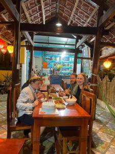 a group of people sitting at a table eating food at Phong Nha Ecolodge Homestay Tour and Restaurant in Bố Trạch