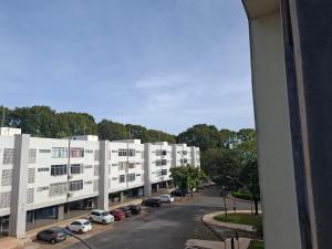 a view of a street with cars parked in a parking lot at Asa Norte - Suíte Premium - Conforto e praticidade in Brasília