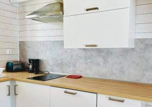 a kitchen with white cabinets and a counter top at TuNaChill in Dziwnów +12 photos