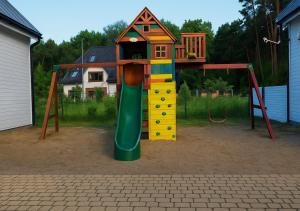 a playground with a slide and a house on it at TuNaChill in Dziwnów