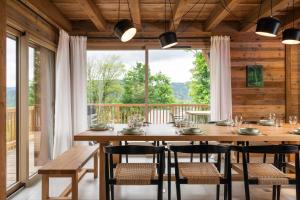 a dining room with a table and chairs and a large window at Chalet Le Cocon des Marmottes Vue Imprenable Confort Haut de Gamme & Services sur Mesure in Gérardmer