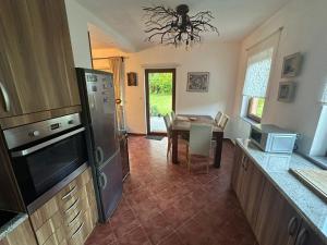 a kitchen with a table and a dining room at Cottage on Una in Bihać