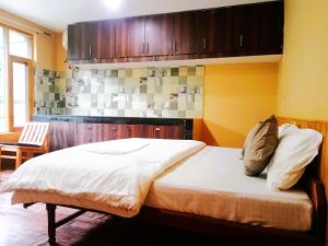 PalchānShree Dev Narayan Hotel的一间卧室配有白色床单