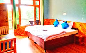 PalchānShree Dev Narayan Hotel的一间带床的卧室，位于一间有窗户的房间里