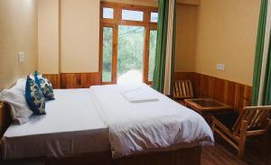 PalchānShree Dev Narayan Hotel的一间有床和窗户的小卧室