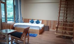 PalchānShree Dev Narayan Hotel的一间卧室配有一张带梯子和桌子的床