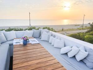 un canapé blanc assis sur un balcon donnant sur la plage dans l'établissement Villa Rosa Del Mare, à Senigallia